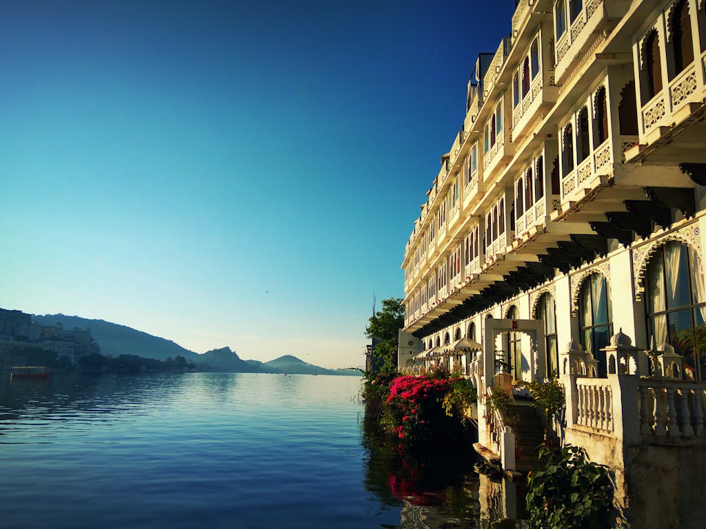 Stunning view of a lakeside palace in Udaipur, reflecting its intricate architecture on the serene water.